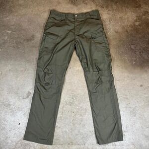 Green tactical cargo pants with multiple pockets, zippers, and adjustable waist